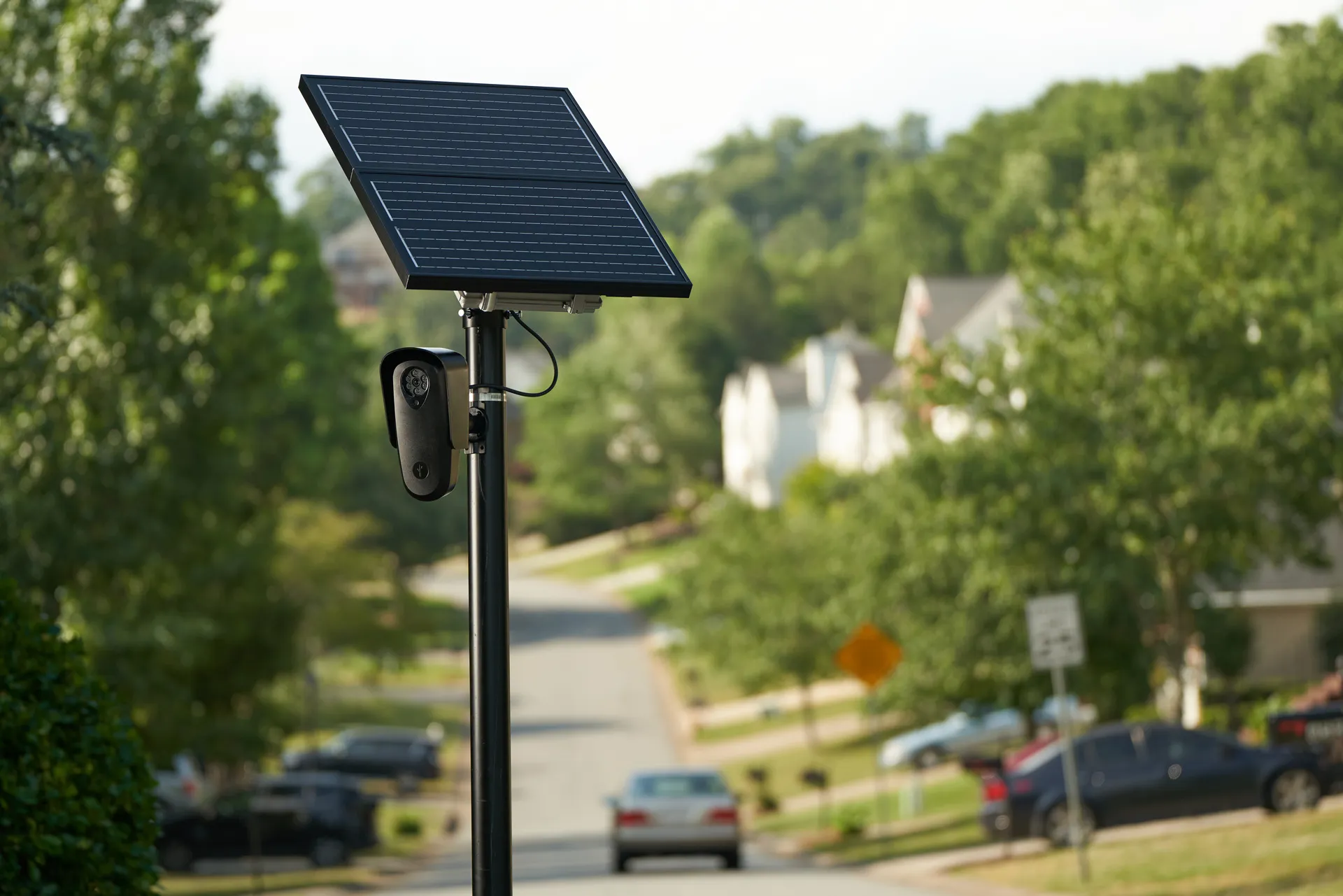 A Flock Safety license-plate reader camera mounted on a pole beside a Texas roadway.