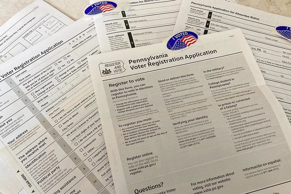 A Pennsylvania voter registration application and related informational materials on a table