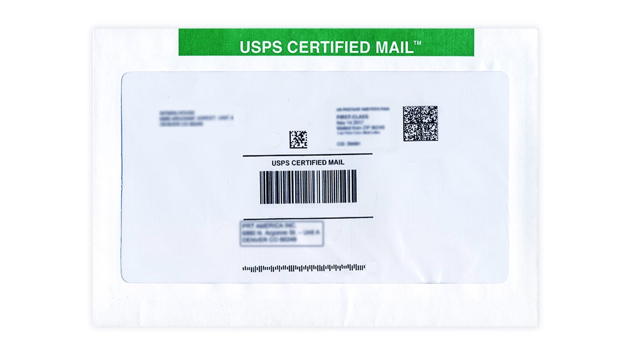 A USPS Certified Mail receipt and label next to an addressed envelope on a post office counter