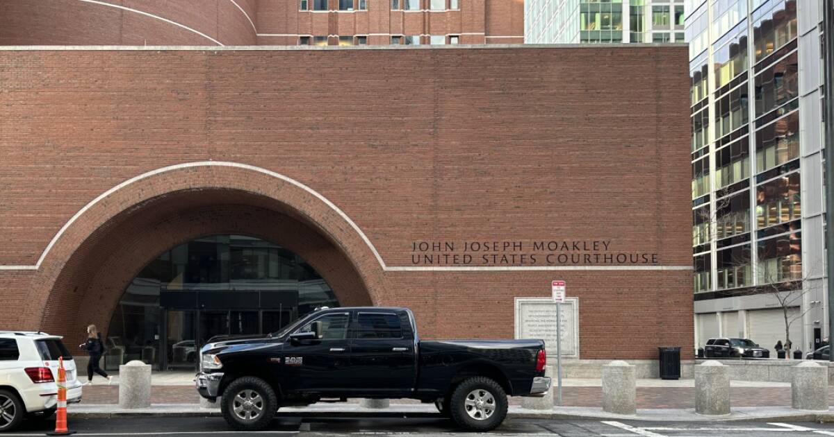 A busy courthouse entrance in Boston with lawyers and members of the public walking up the steps, news photography style