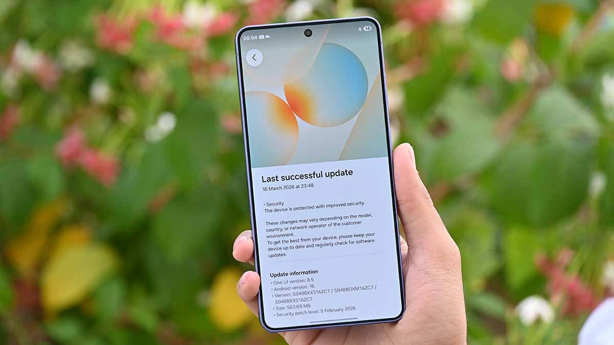 A close-up photograph of a person holding a smartphone with a lit lock screen in a dim indoor setting, news photography style