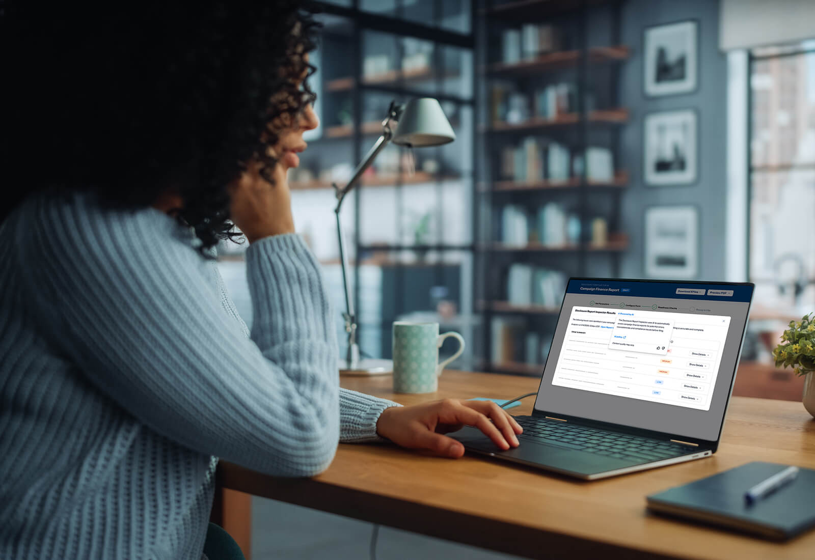 A close-up photograph of campaign finance disclosure reports and printed filings spread across an office desk while a person reviews them with a pen