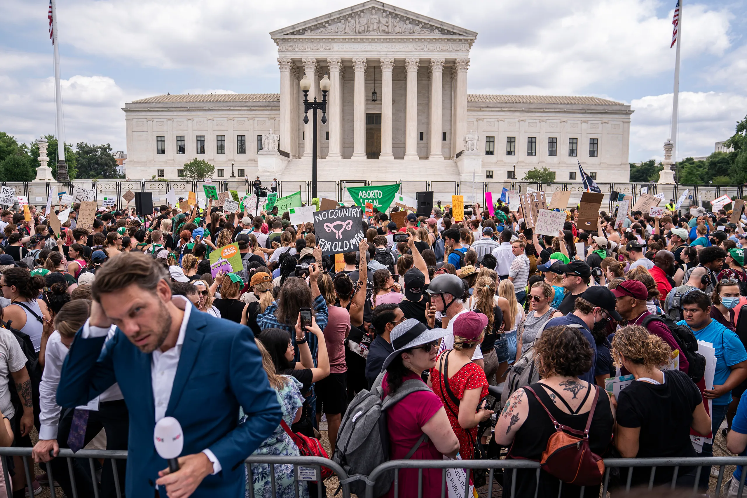 A crowd gathered on the steps outside the United States Supreme Court building during a major decision day, news photography style