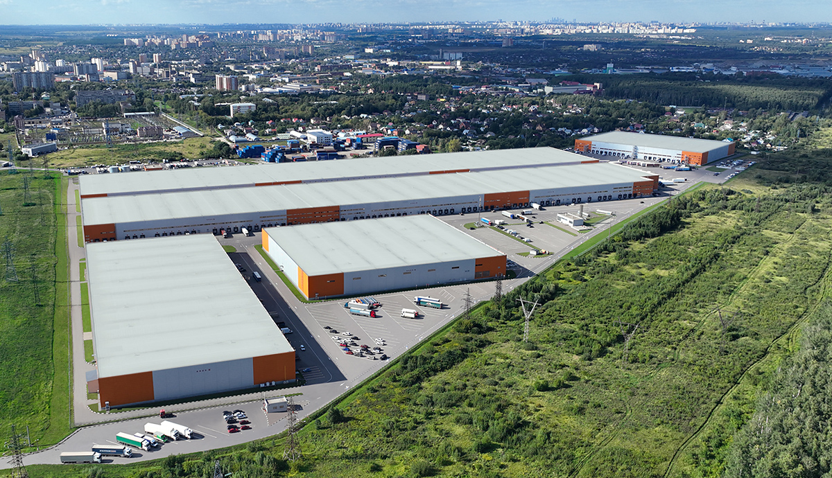 A daytime photograph of an industrial district in Elektrostal, Moscow Oblast, showing warehouses and factory buildings along a roadway