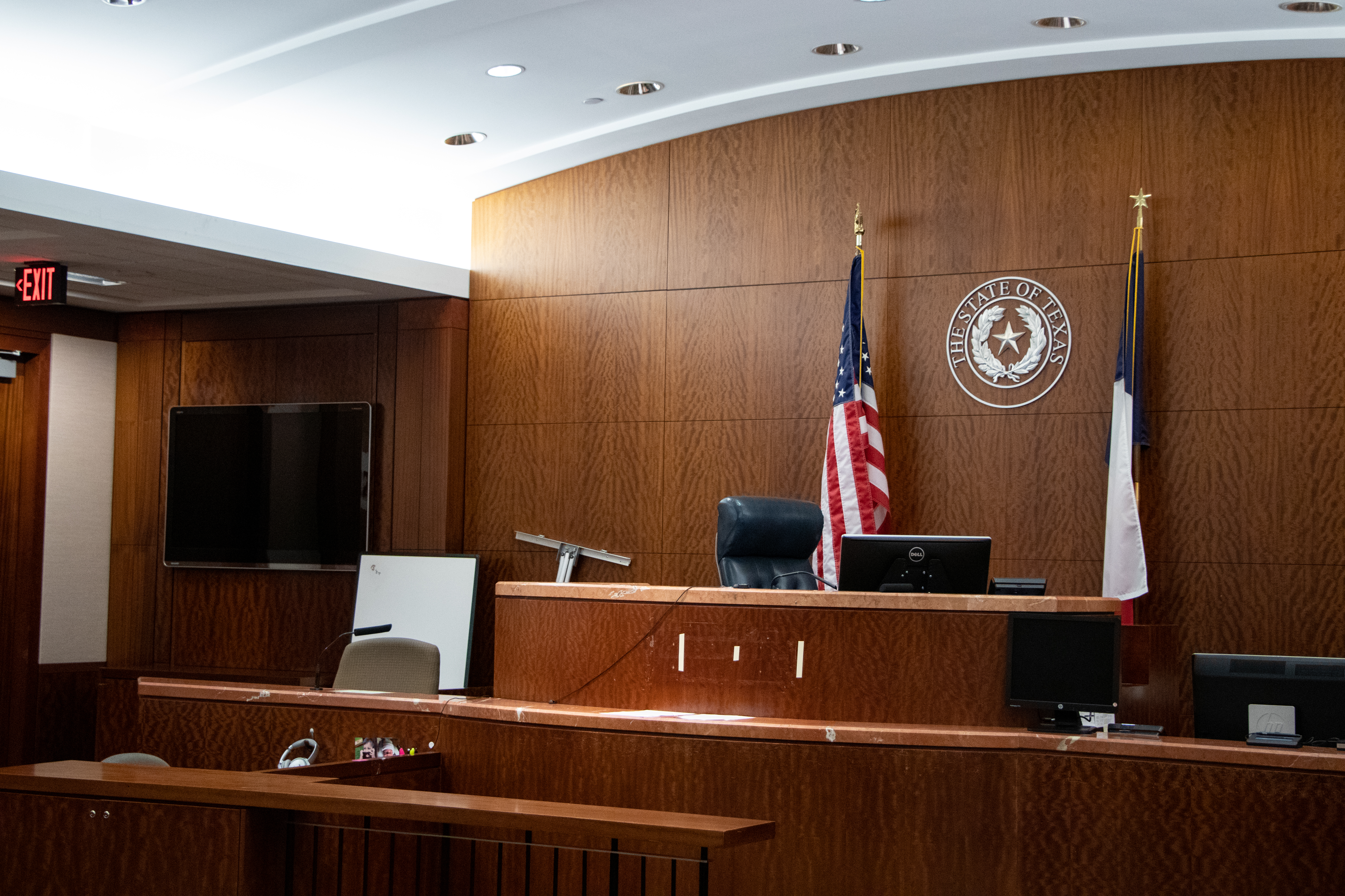 A family court hearing in a real courtroom with attorneys standing at lecterns and a judge listening from the bench, candid courthouse photography style