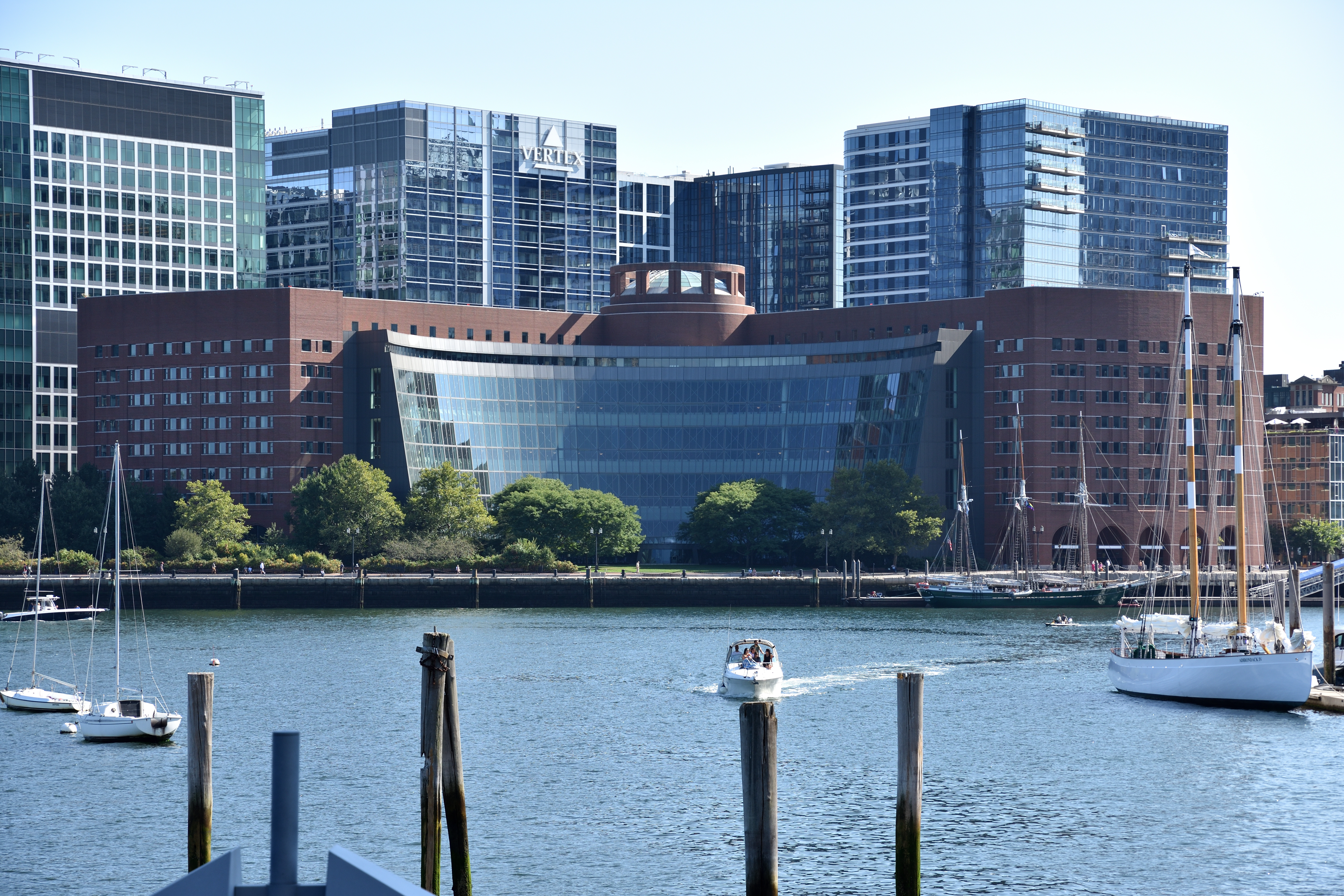 A federal courthouse exterior in Boston with pedestrians walking past stone columns and wide steps, photographed at street level in overcast daylight, realistic news photography