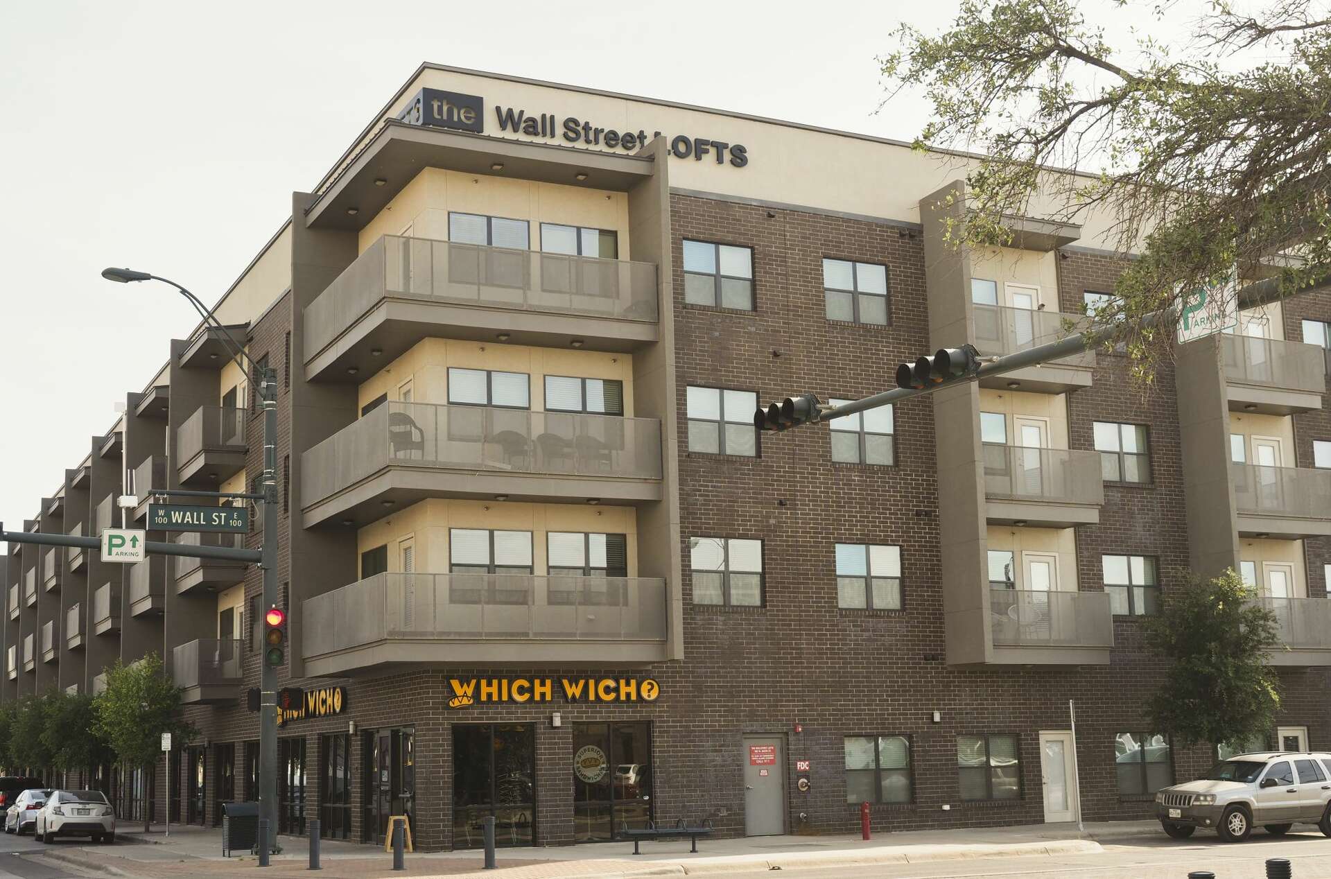 A gated apartment complex entrance in Midland, Texas during daylight, photographed in a realistic news style