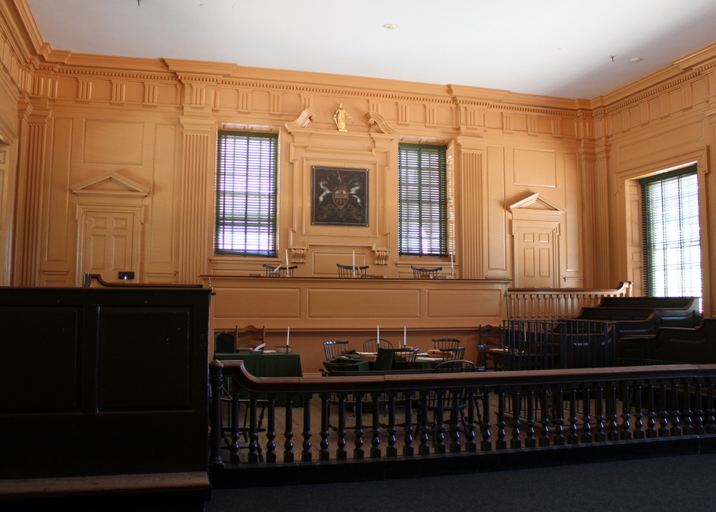 A historic courtroom interior inside Independence Hall in Philadelphia with wooden benches and soft natural light, photographed as a real interior space