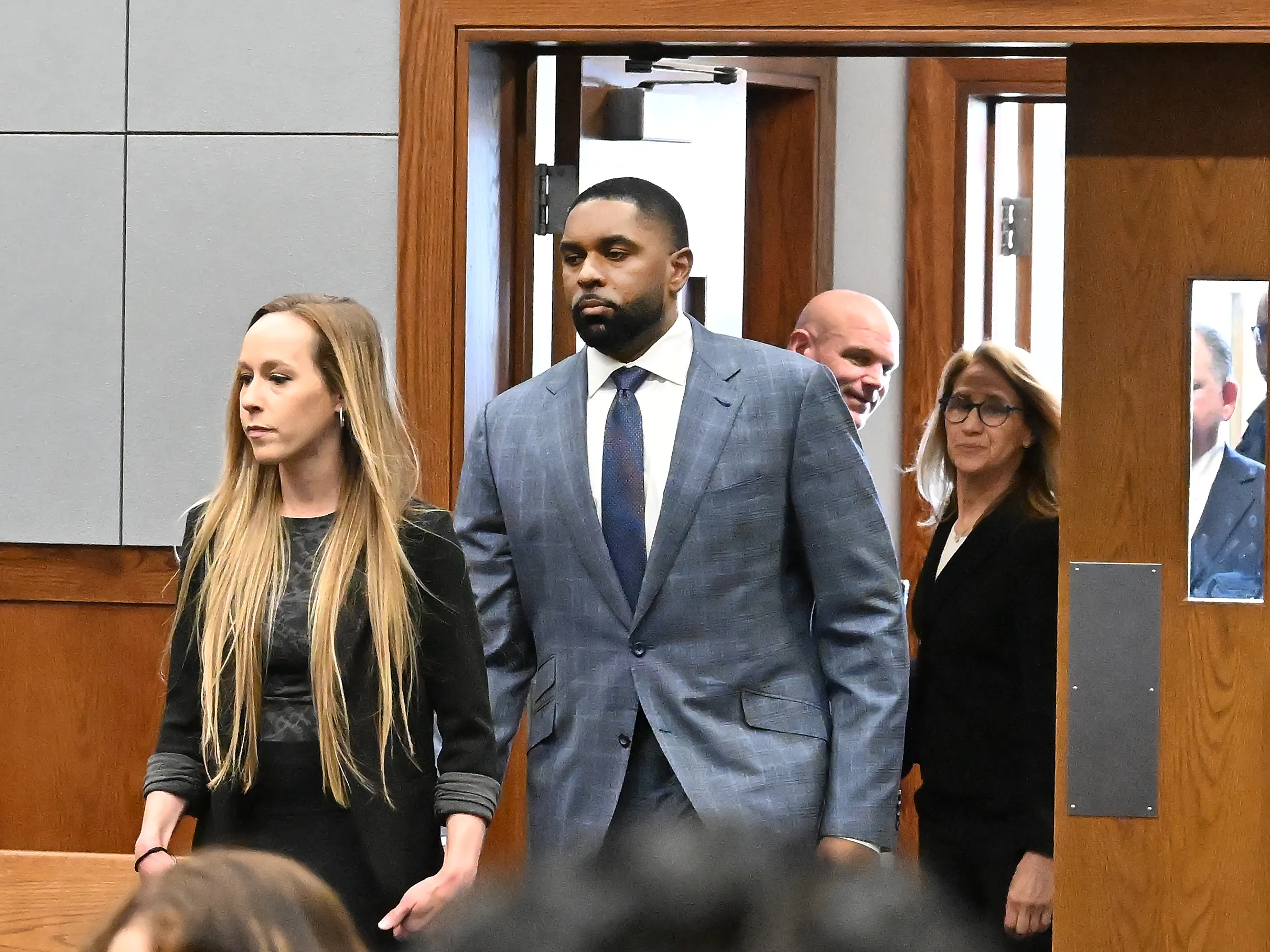 A judge at the bench during a sentencing hearing in a state courtroom while attorneys stand at counsel table, realistic news photography style
