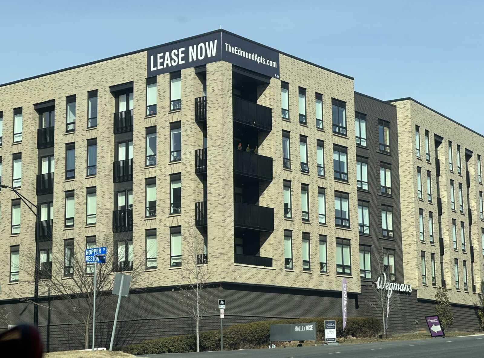 A landlord and tenant sitting at a table signing a residential lease agreement in an apartment office, news photography style