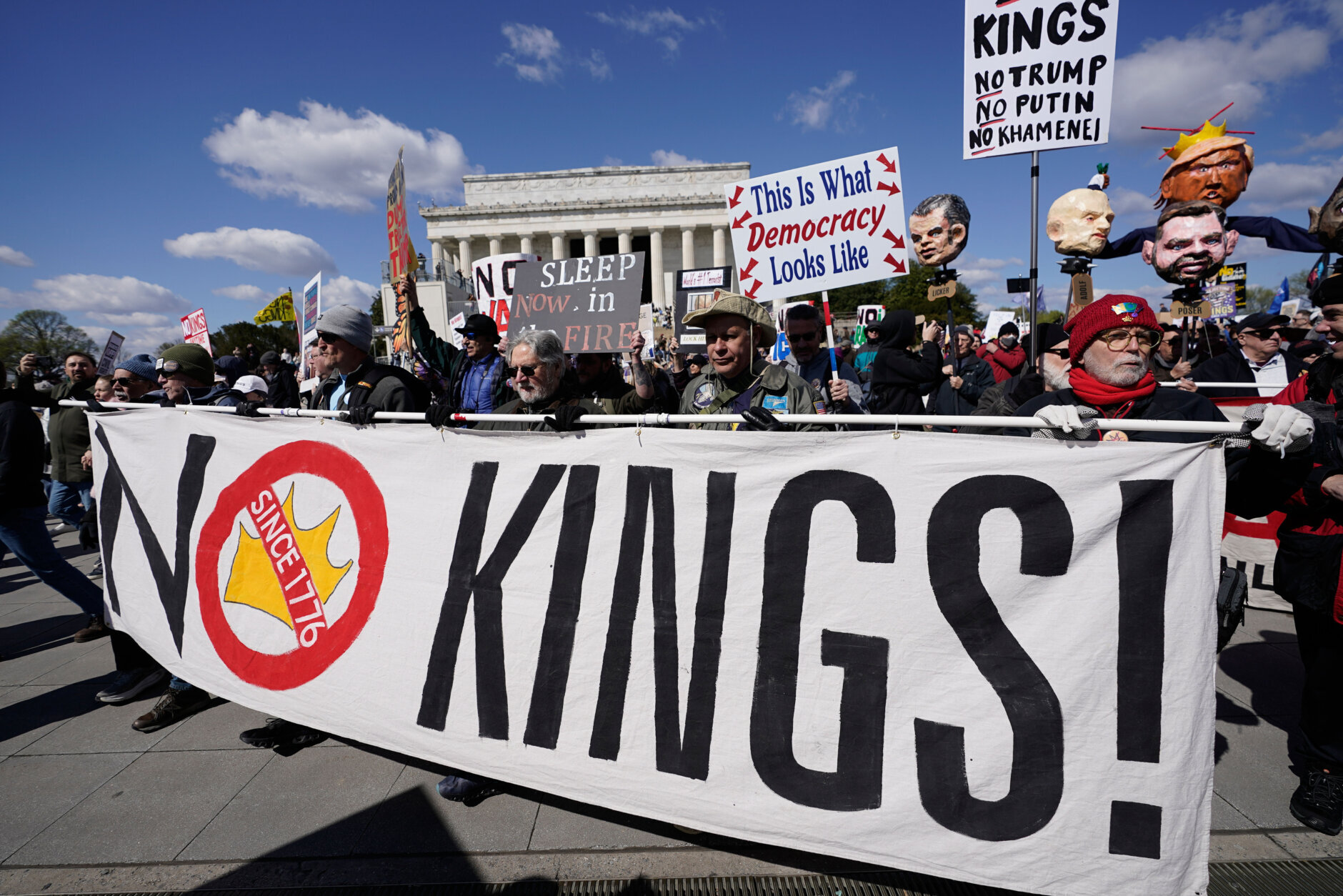 A large crowd of protesters gathered near the Lincoln Memorial in Washington, D.C., holding signs during a daytime demonstration, news photography style