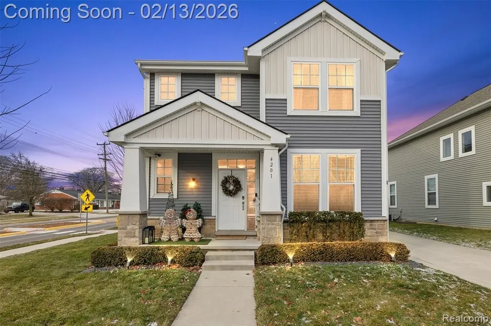 A large suburban home exterior in Royal Oak, Michigan, photographed from the street in daylight, news photography style