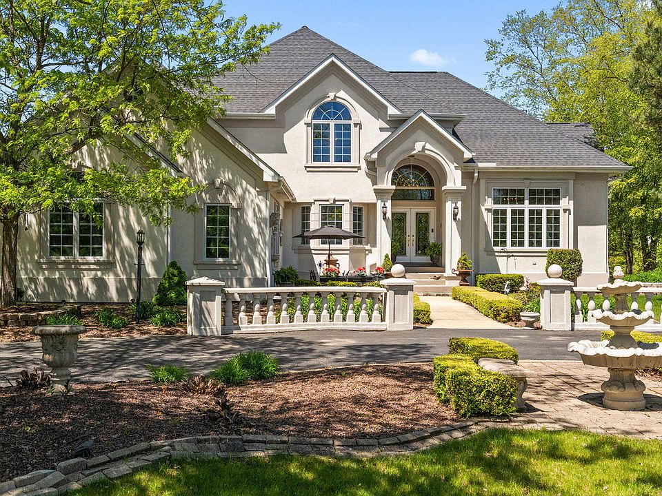 A large suburban home exterior in Royal Oak, Michigan, photographed from the street in daylight, news photography style