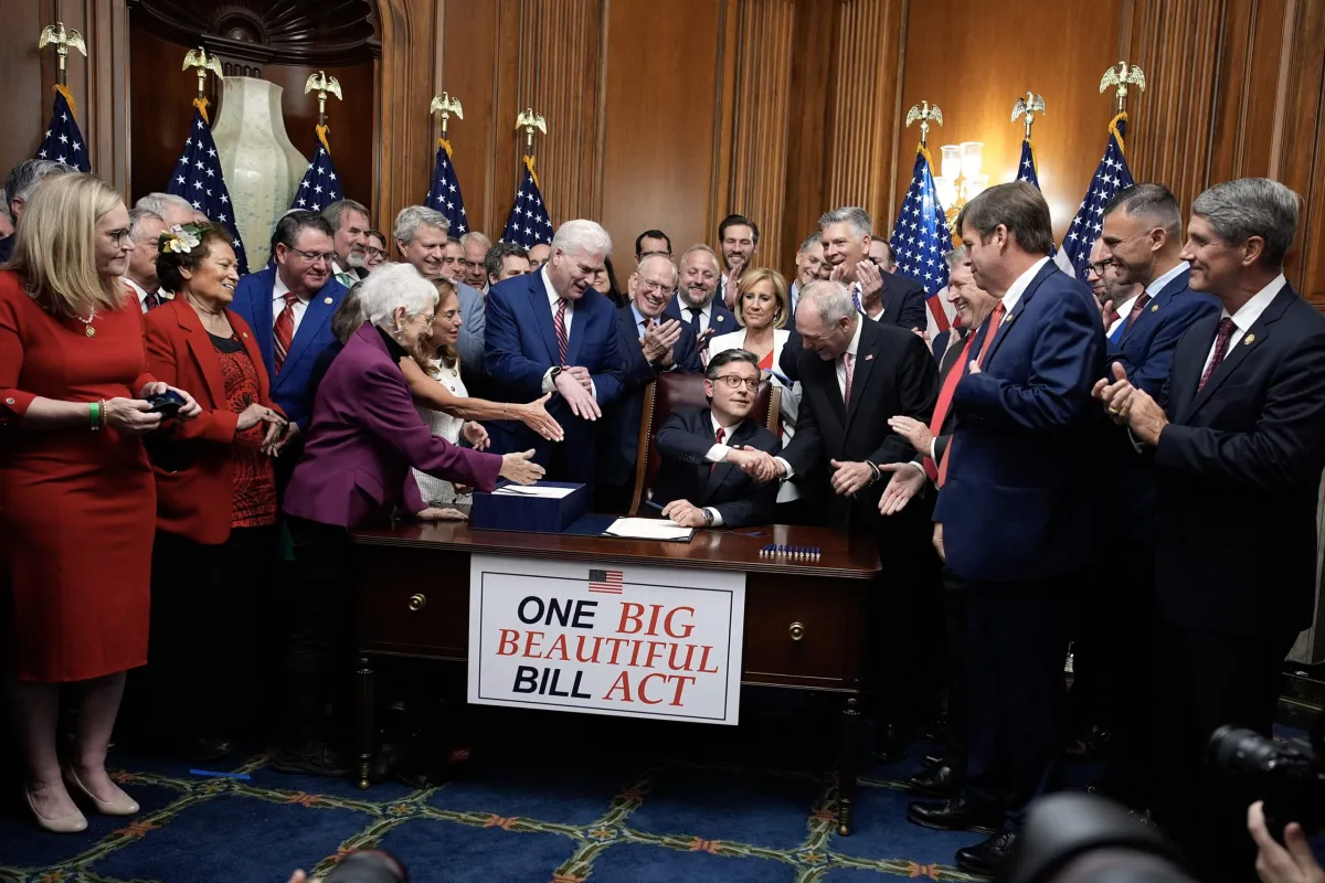 A legislative staffer in a Capitol Hill office reviewing printed bill pages on a desk with folders and notes, candid news photo style