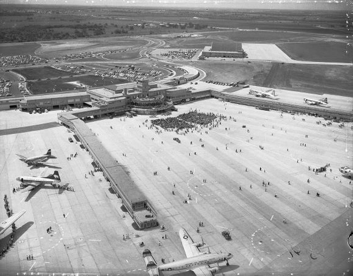 A mid-century United States Air Force runway scene in daylight with a grounded military aircraft in the background and uniformed personnel nearby, realistic historical news photography style
