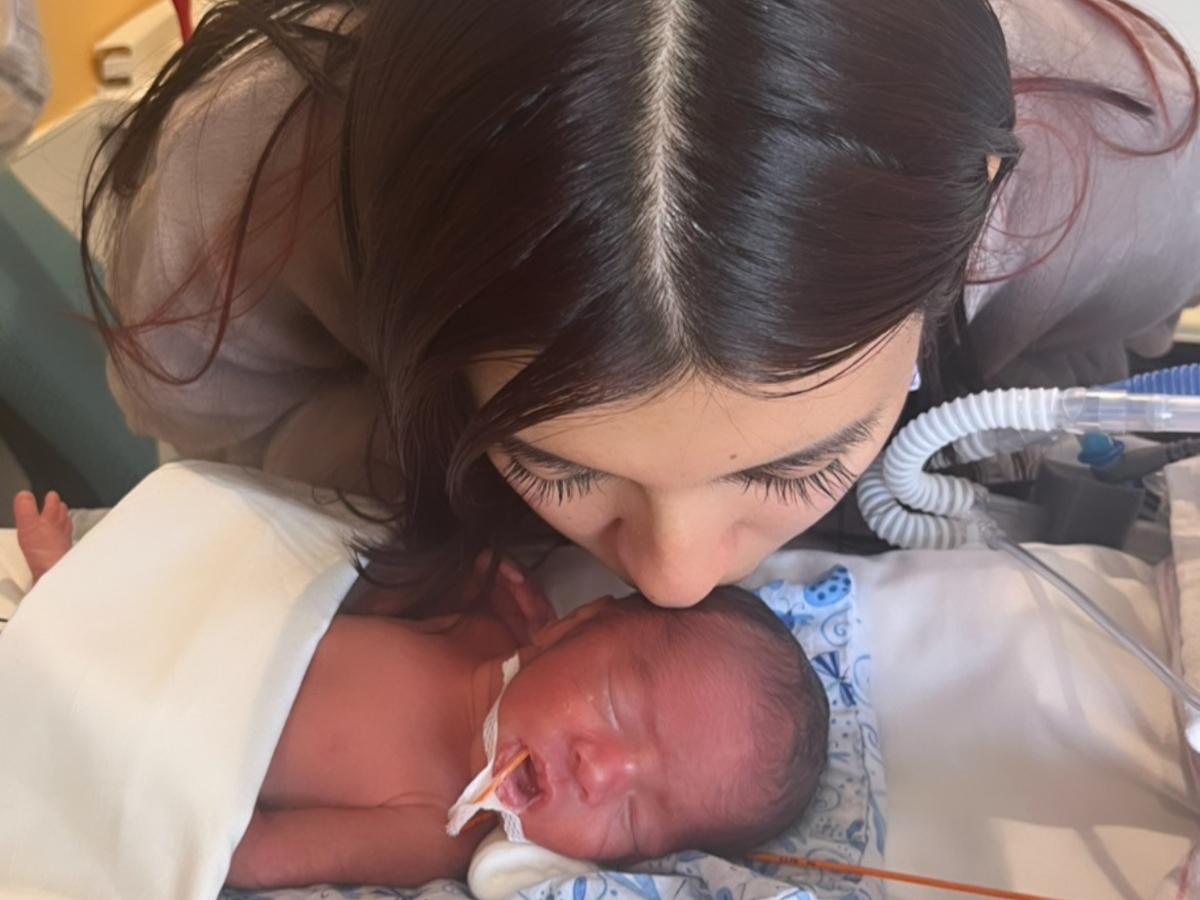 A newborn baby in a hospital bassinet in the United States with a soft blanket, candid documentary photo