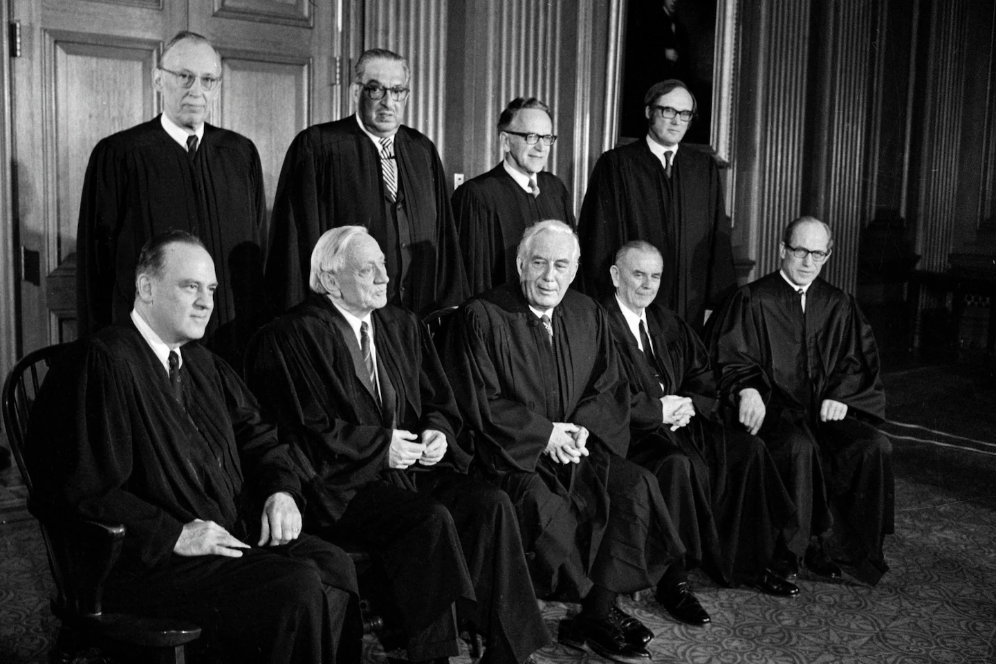 A news-style photograph of the United States Supreme Court building on an overcast day with people gathered on the steps, evoking the day of a major capital punishment decision in Washington, D.C.