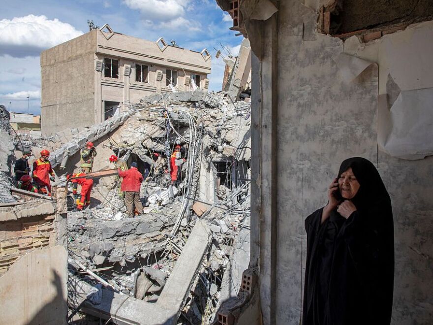 A night-time view of Prince Sultan Air Base in Saudi Arabia with emergency vehicles responding near a runway after an incoming missile and drone strike, realistic news photography style