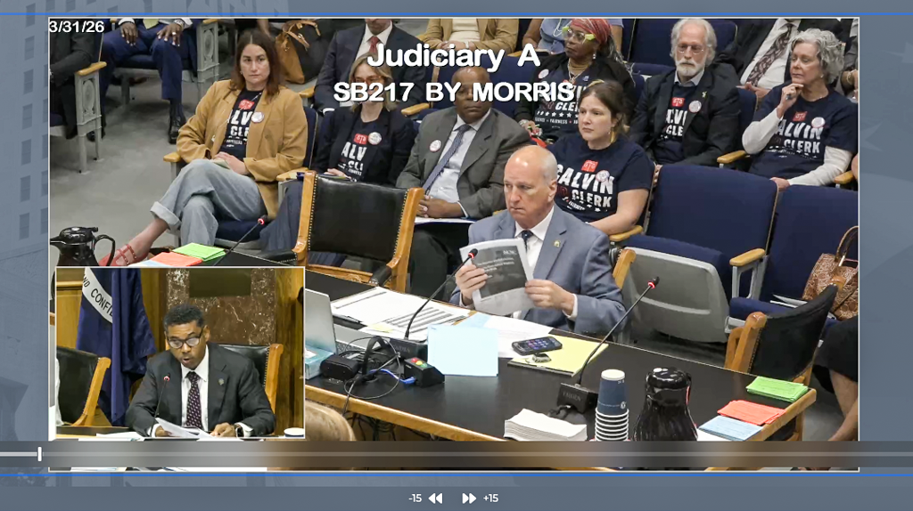 A person holding a stamped civil complaint packet while walking up the steps of a state courthouse, news photography style
