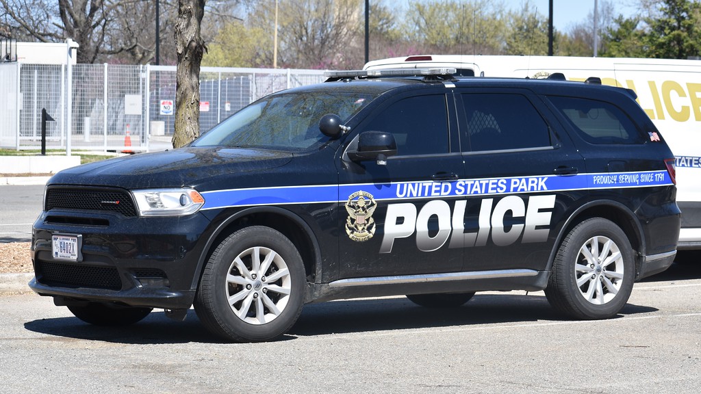 A photograph of a United States Park Police officer near a marked patrol vehicle on the National Mall in Washington, D.C.