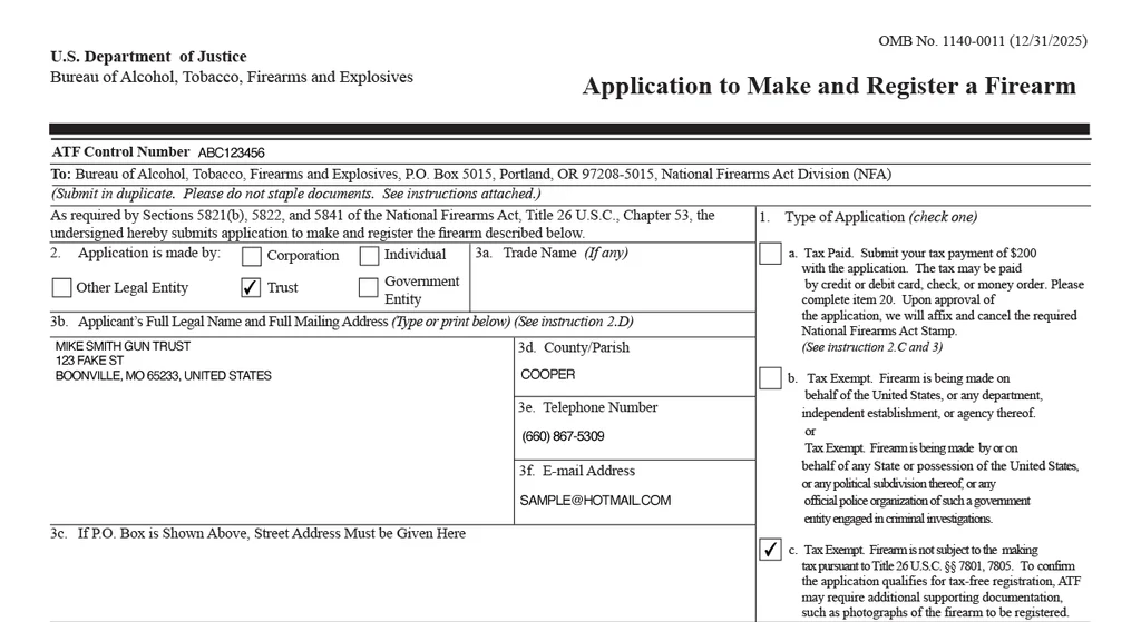 A photograph of an ATF Form 4 application packet and supporting paperwork for an NFA transfer, laid out on a desk with visible form fields and signature blocks