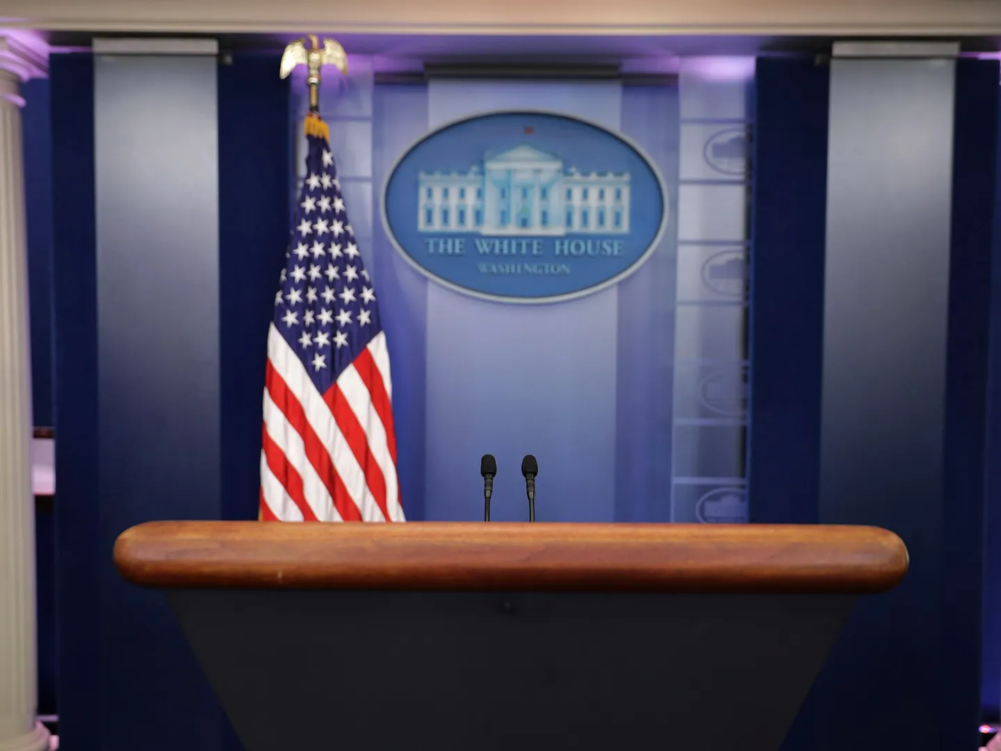 A podium in the White House press briefing room in Washington, DC with rows of empty seats in the background, real news photograph
