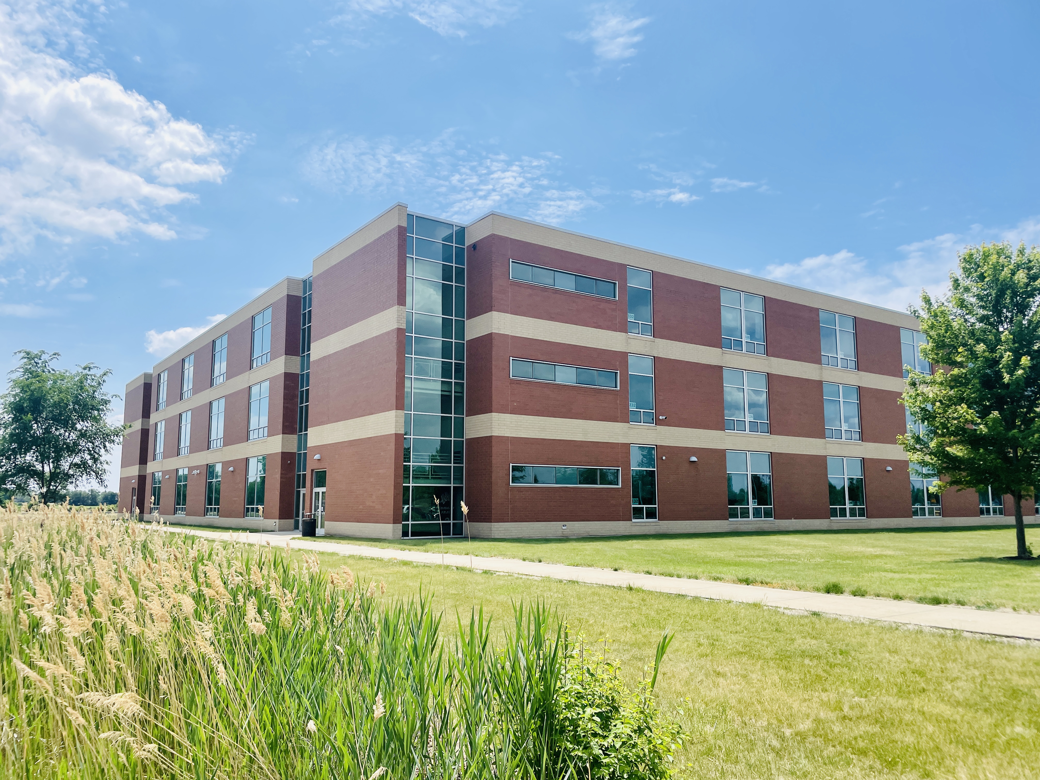A public high school campus in Illinois on a clear day with students walking between buildings, news photography style