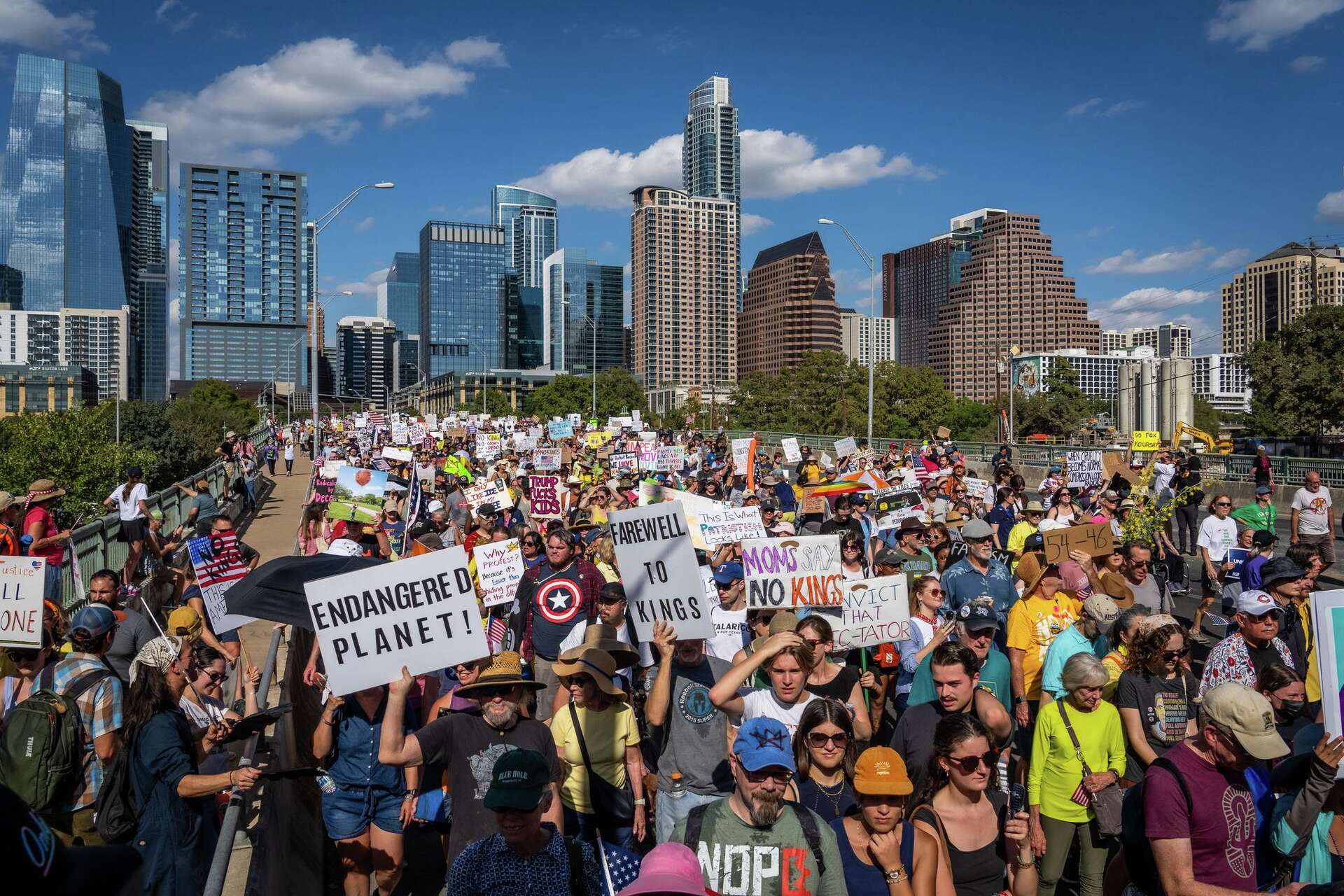 A public protest in Austin, Texas with demonstrators gathered outdoors holding signs