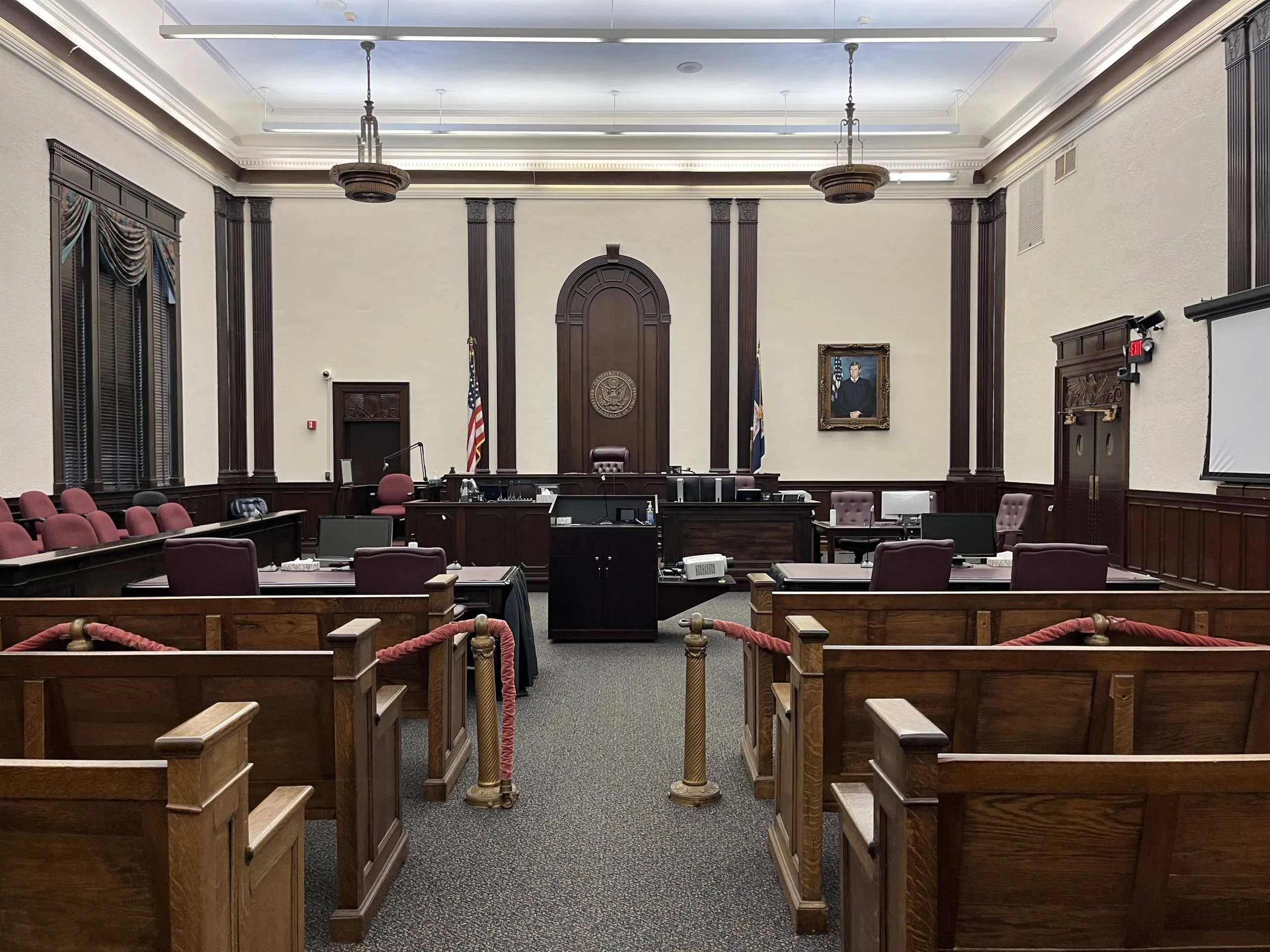 A quiet federal district courtroom with the judge's bench and counsel tables visible before a hearing begins, realistic news photography style