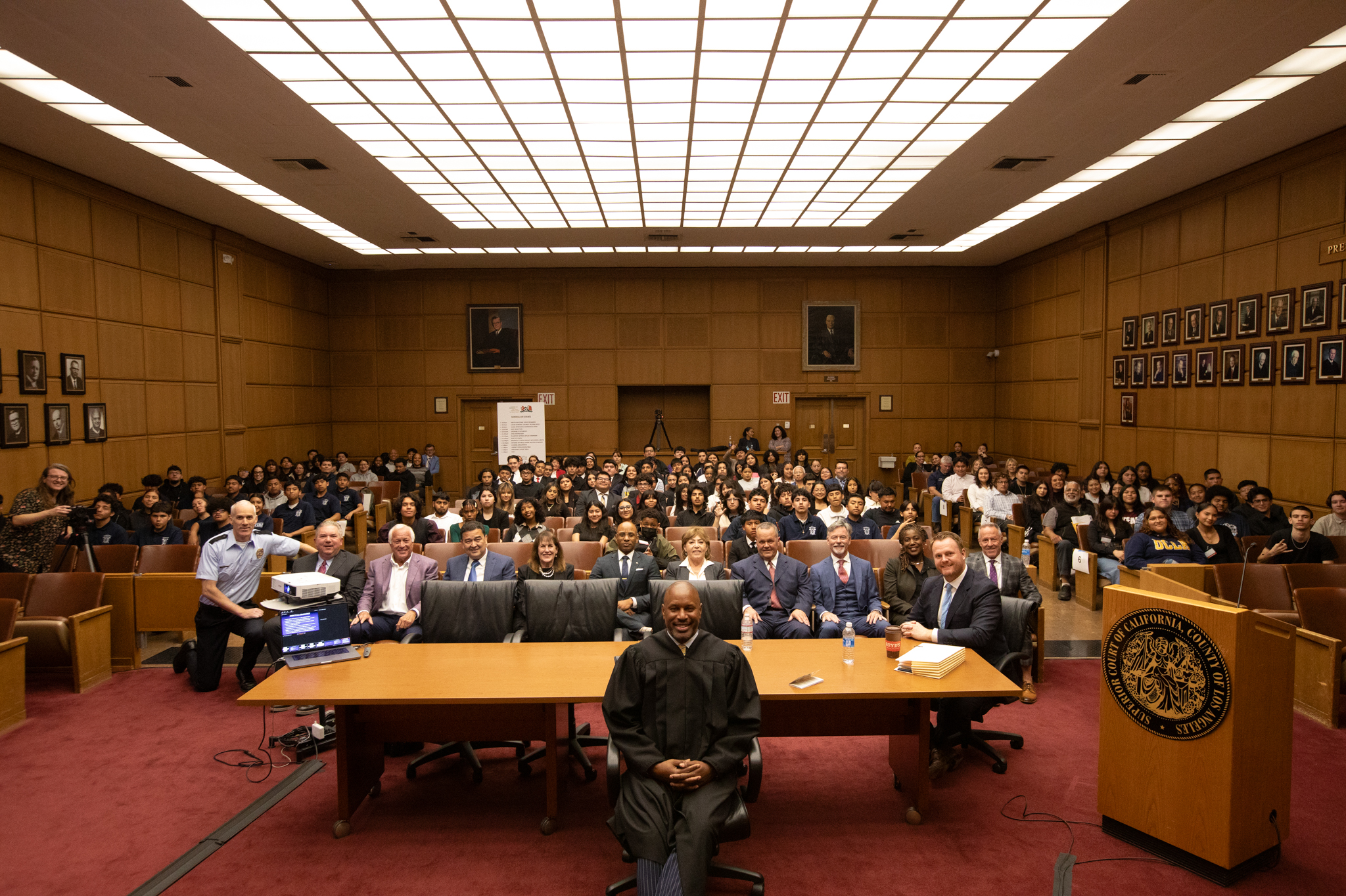 A real courtroom during a jury trial, with a judge on the bench, attorneys at counsel tables, and jurors seated in the jury box, documentary photography style