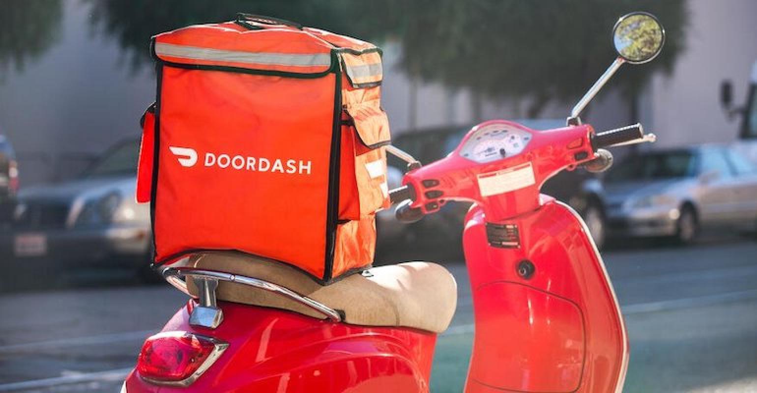 A real-world DoorDash sign or logo on a delivery bag or vehicle in an everyday street setting