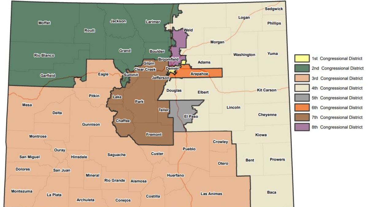 A redistricting staffer working at a computer workstation with detailed district boundary lines visible on the screen, office setting, news photography style