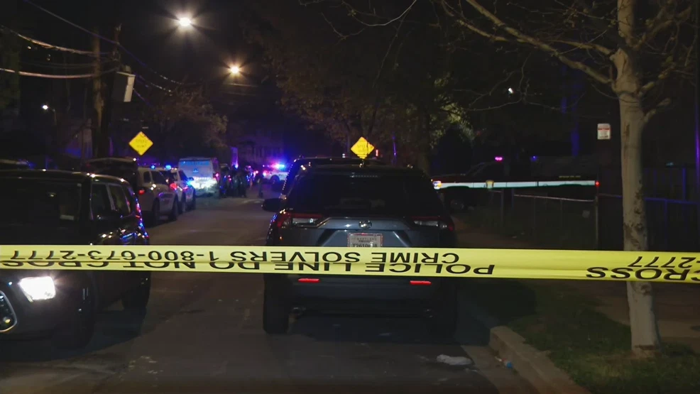 A row of police barricades and flashing patrol lights on a Washington, DC street in the evening, with pedestrians kept at a distance, news photography style