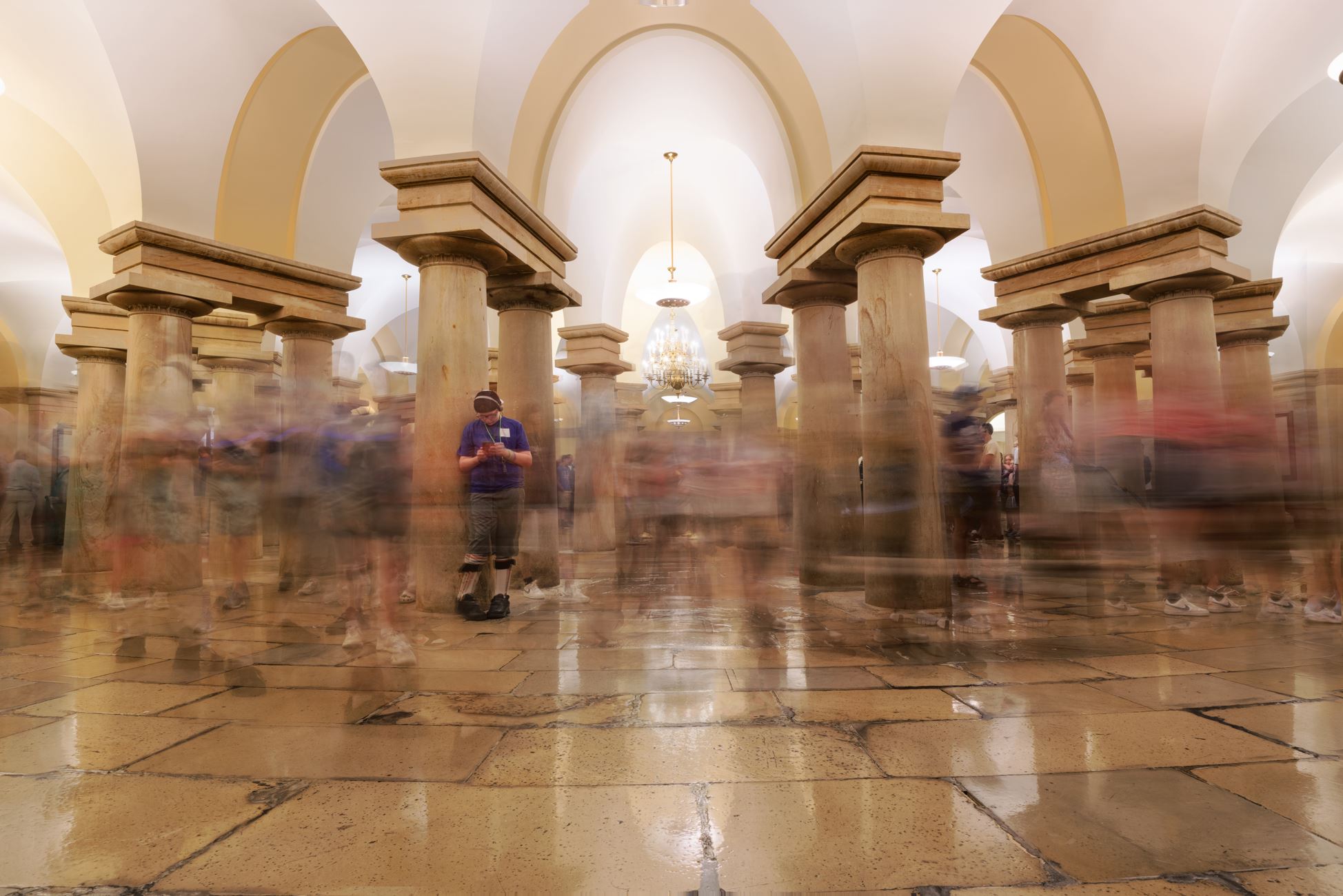 A security checkpoint inside a United States federal courthouse with metal detectors and a uniformed officer, news photography style