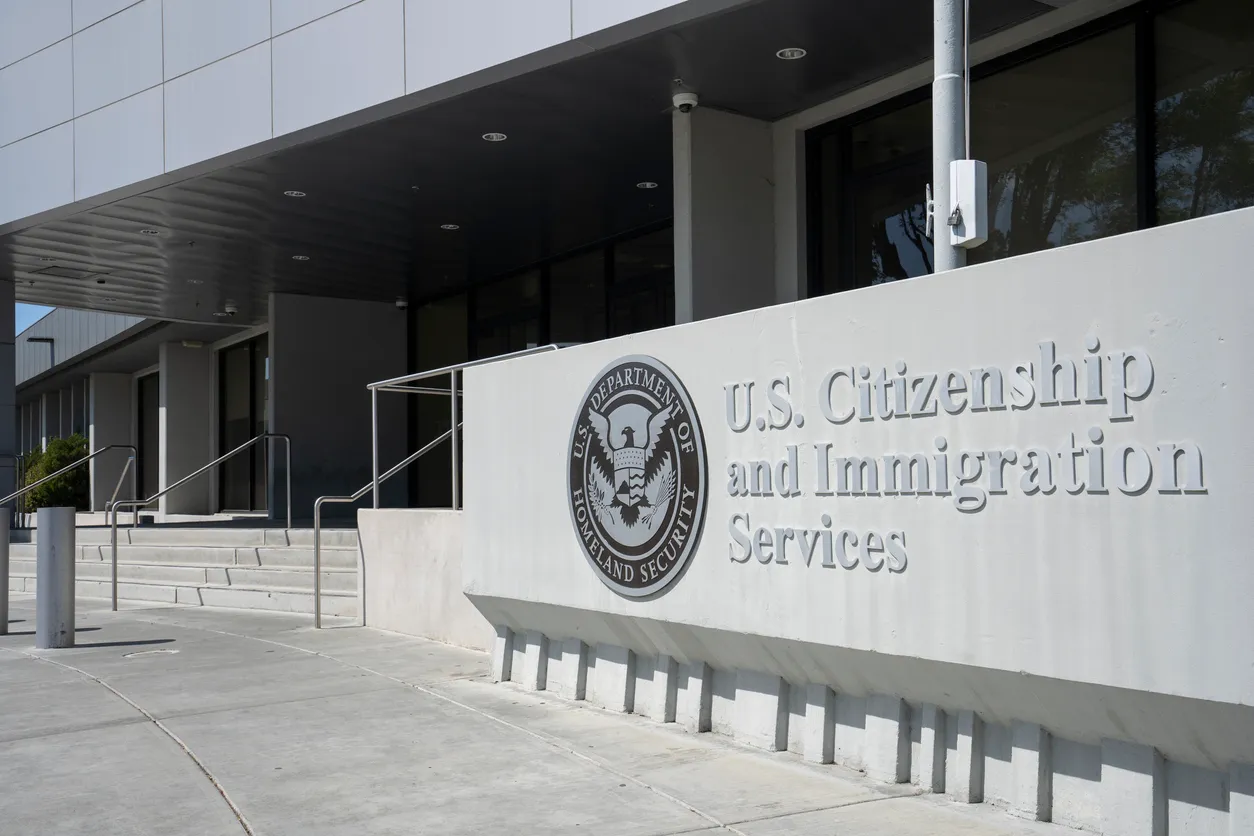 A sign for U.S. Citizenship and Immigration Services outside a federal office building