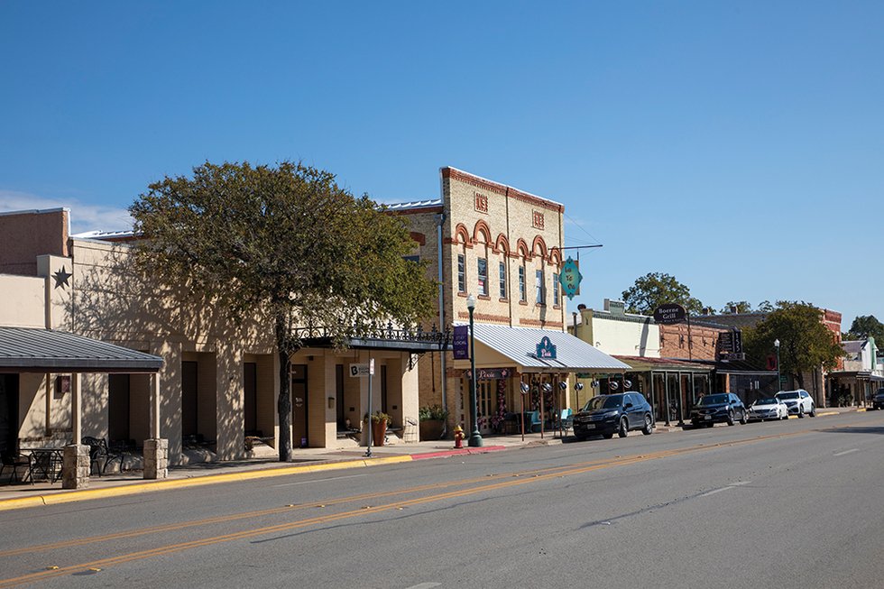 A small Texas rural town main street with local storefronts and a two-lane road, photographed in daylight