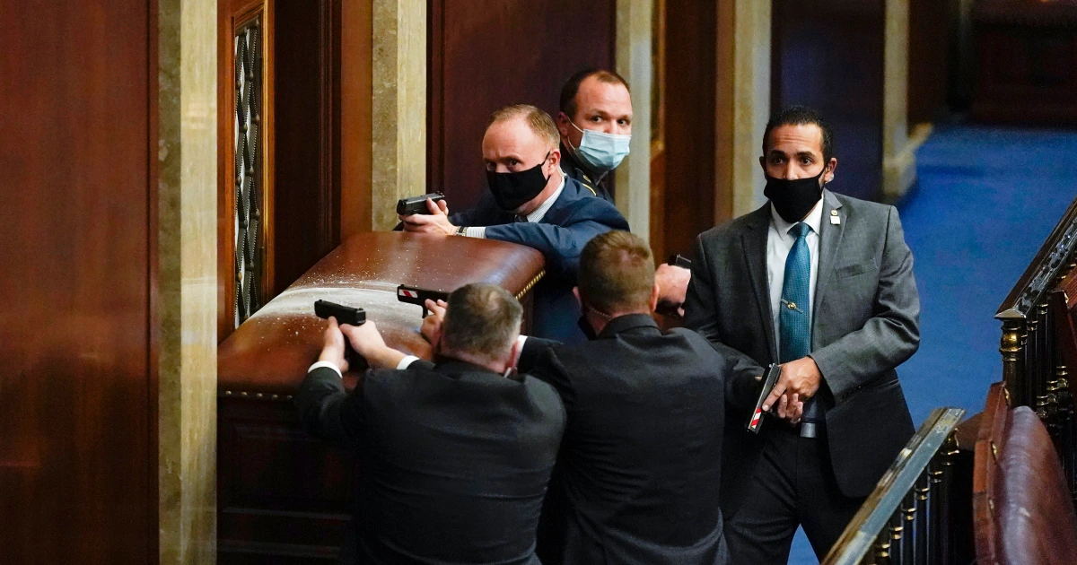 A small group of House members speaking with staff in a Capitol complex hallway, serious expressions and press nearby, news photography style