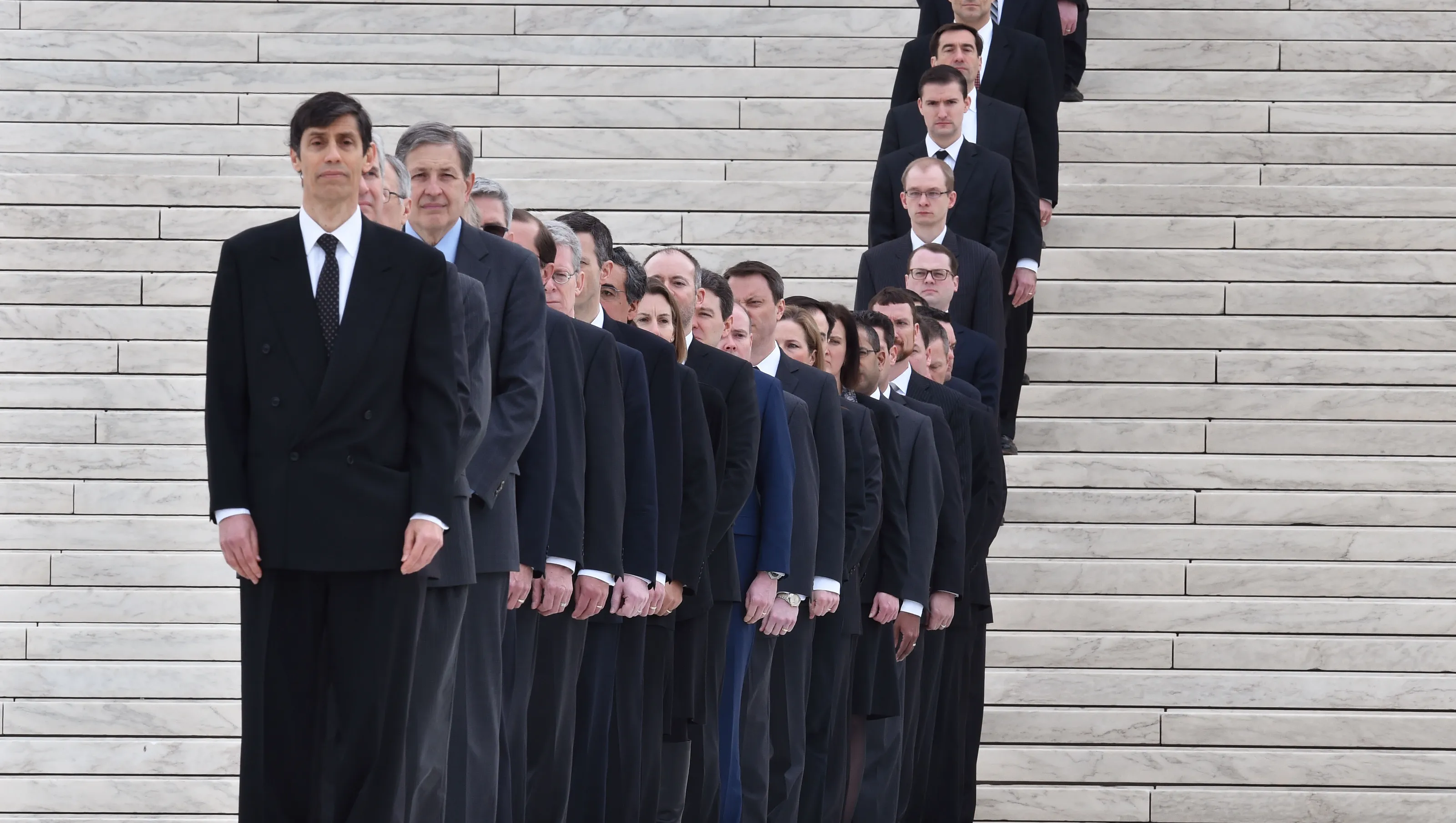A small group of Supreme Court law clerks walking briskly near the Supreme Court building on a weekday morning, news photography style