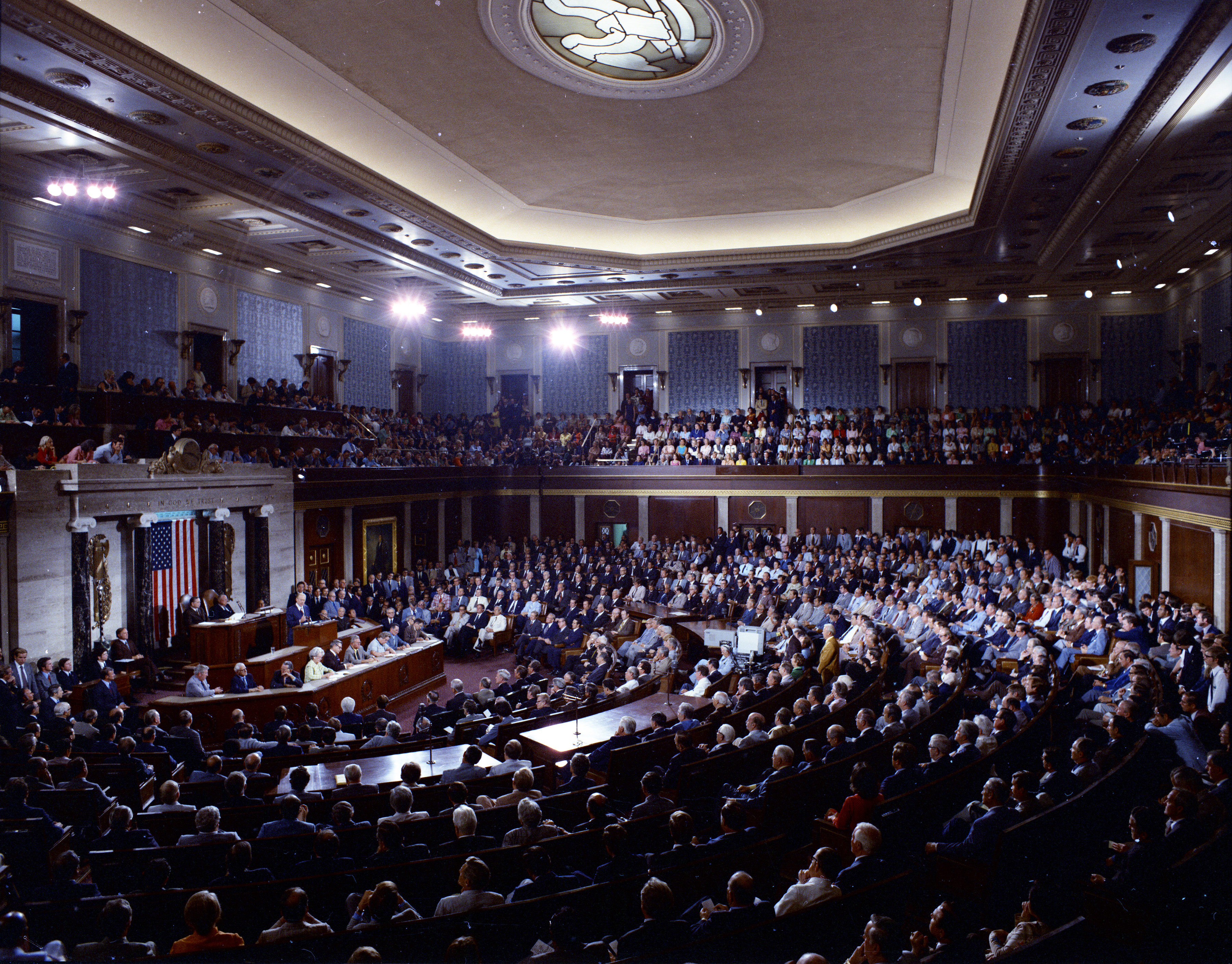 A wide-angle photo of the United States House chamber during a legislative session, with lawmakers seated and the dais visible