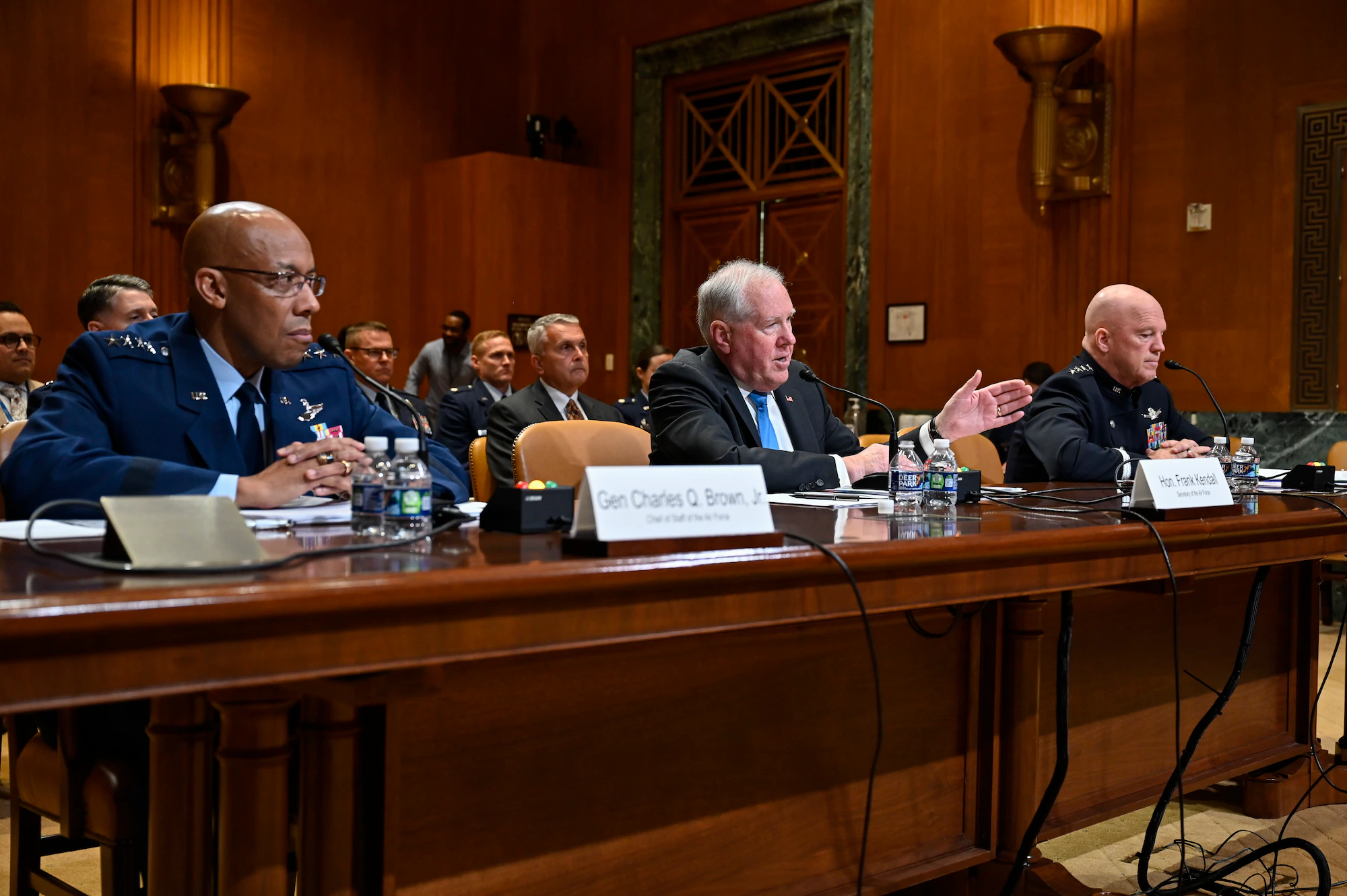 A wide-angle view of a Senate hearing room in Washington, DC during an appropriations hearing, with senators seated and witnesses at a table, news photography style