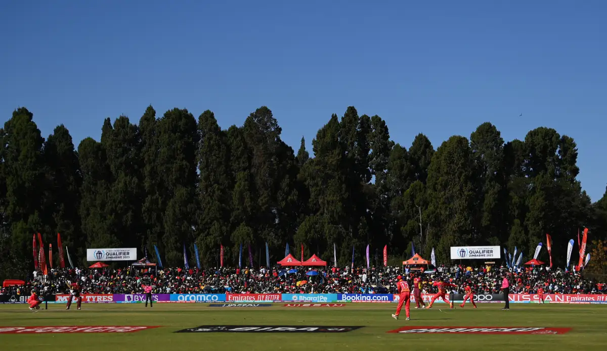 A wide view of Harare Sports Club in Zimbabwe during an international cricket match, with the pitch centered and spectators in the stands