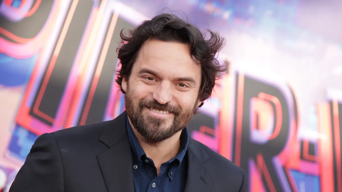 Actor Jake Johnson posing for photographers at a public red carpet event