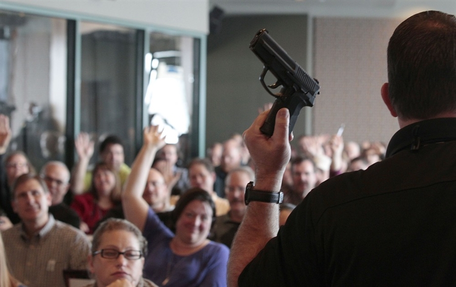 Adults in a classroom-style training setting taking notes during a safety course, news photography style