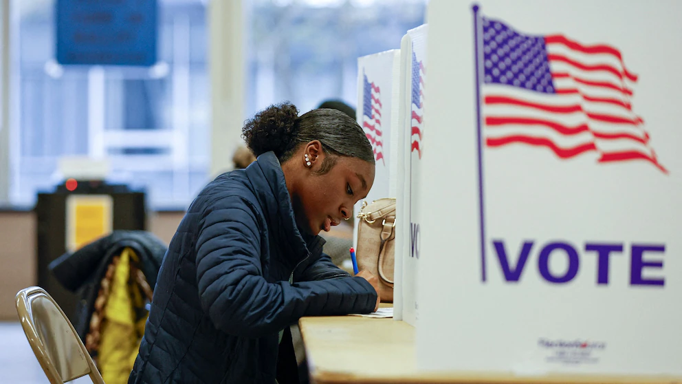 An 'I Voted' sticker and a ballot box at a polling place, illustrating U.S. election participation rules