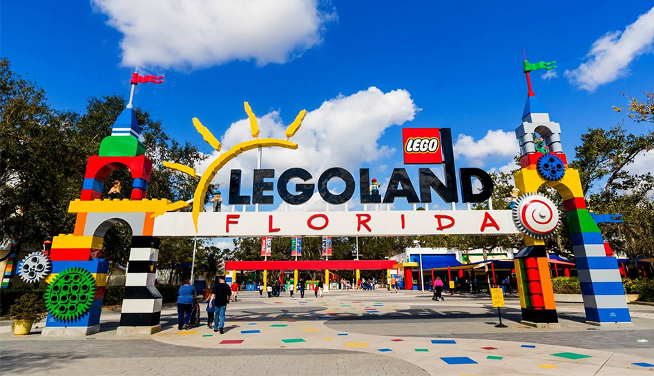 An exterior view of a major Florida theme park entrance area with ticket booths and visitors