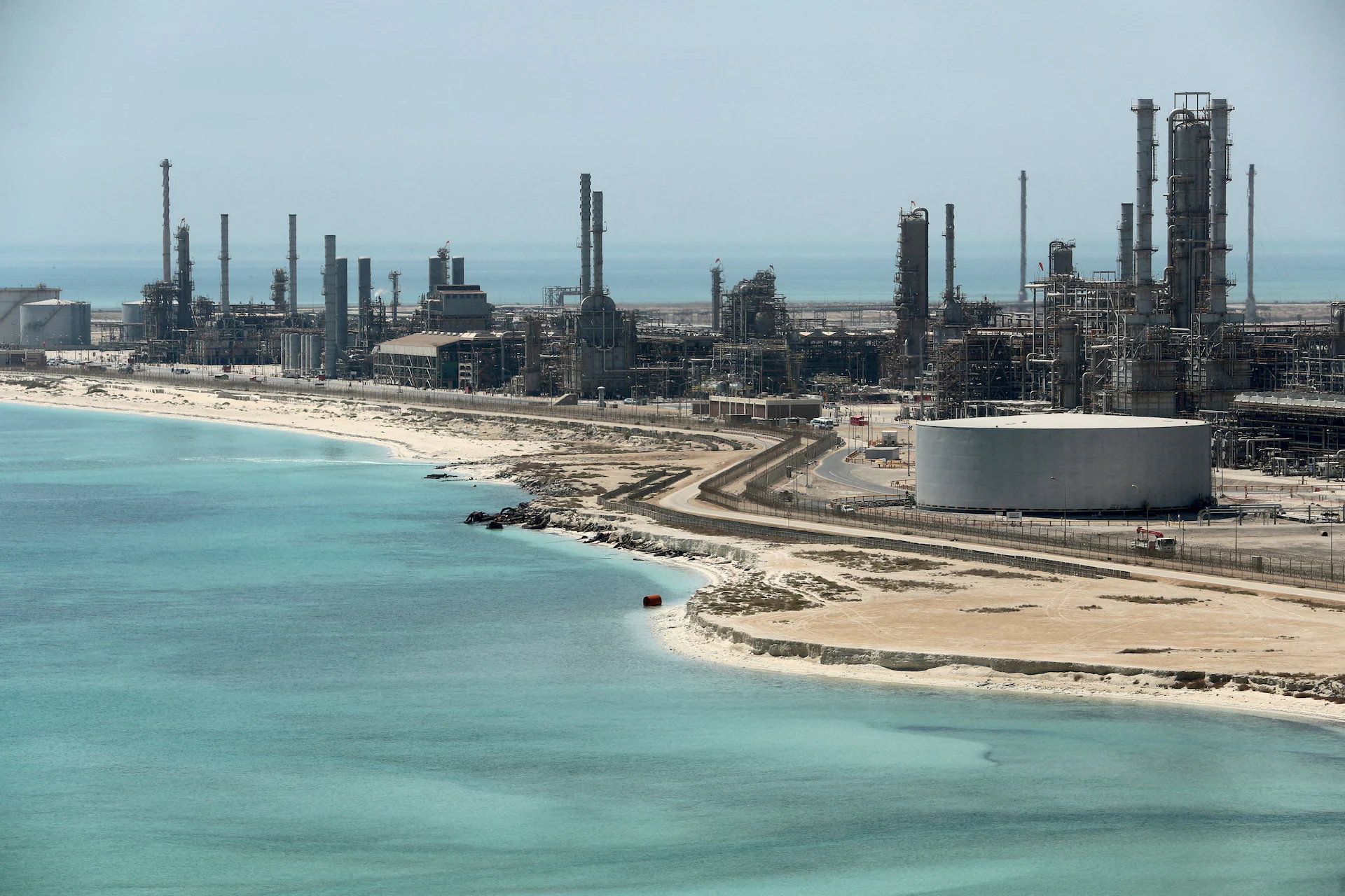 An oil refinery complex with towers and pipes photographed from a distance