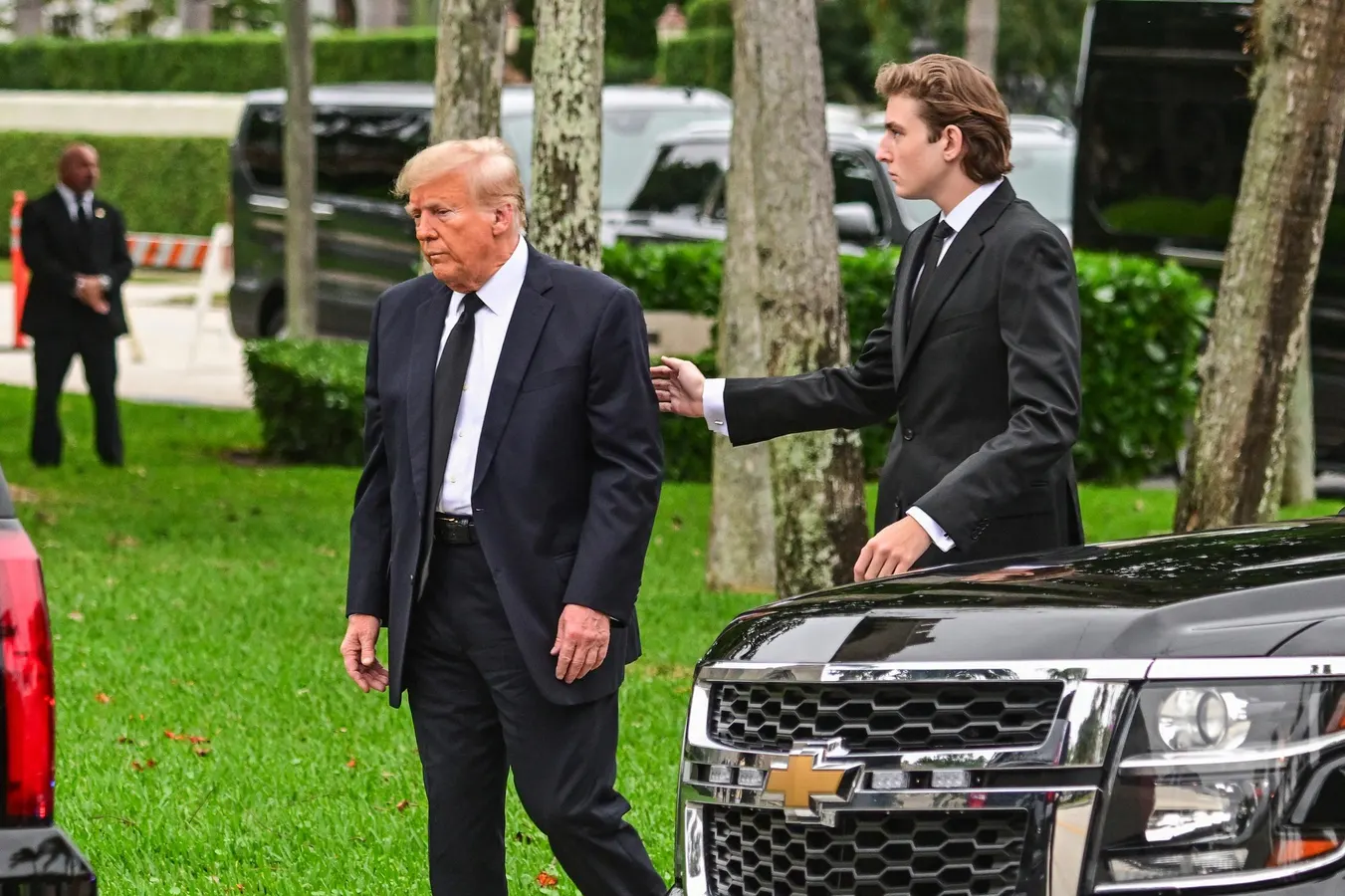 Barron Trump attending a public event with visible security presence, captured as a straightforward real-world photograph