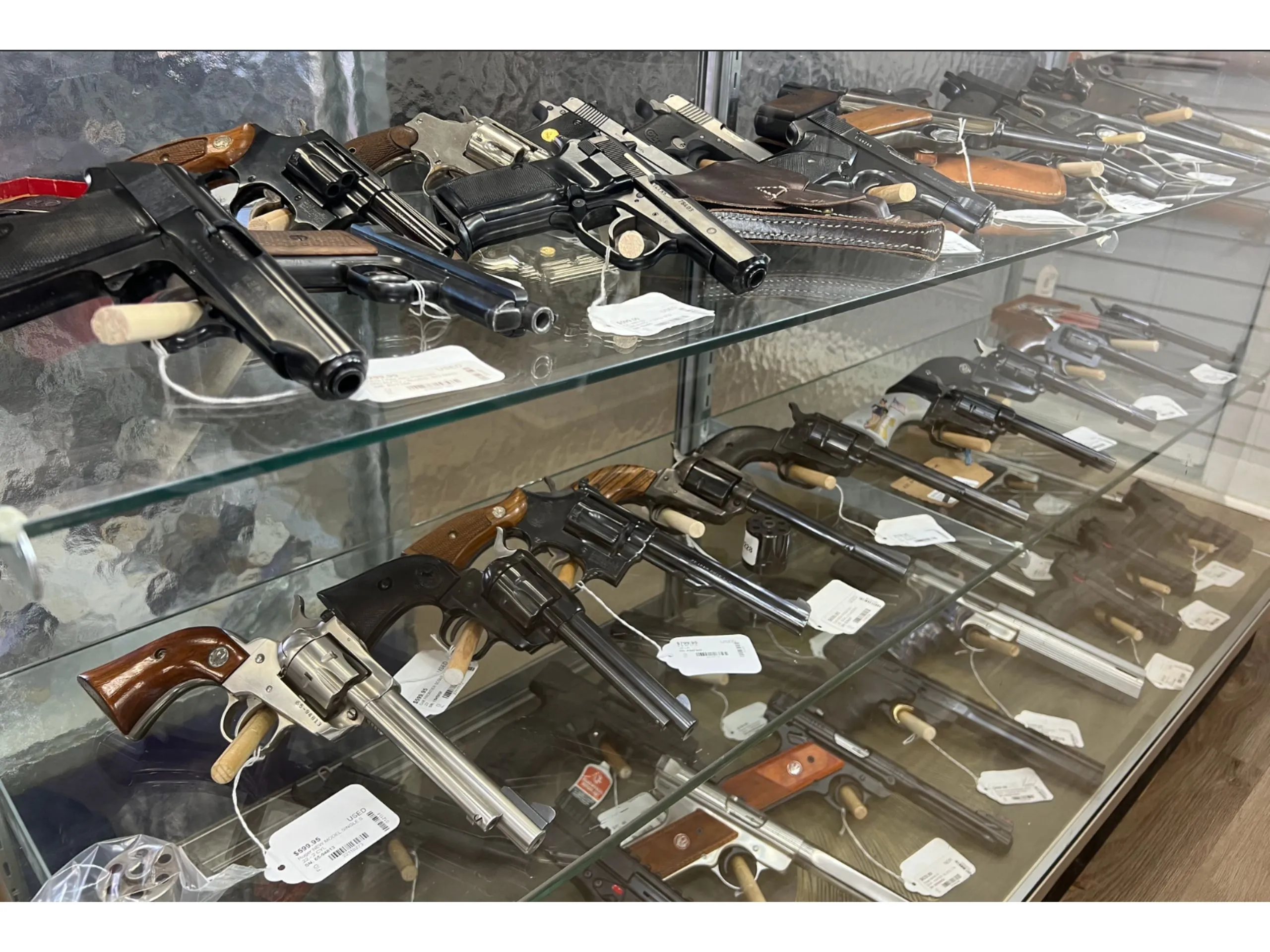 Ben Goldberg inside a pawn and firearms shop in Henrico County, Virginia, speaking with customers at a counter, news photography style