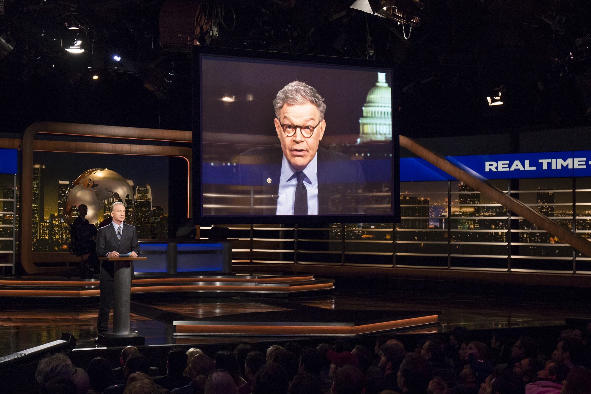 Bill Maher on a studio set during a taping, photographed in a candid stage moment