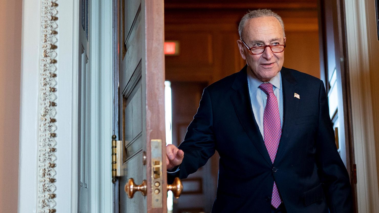 Chuck Schumer speaking on the Senate floor with senators seated behind him, candid news photography style